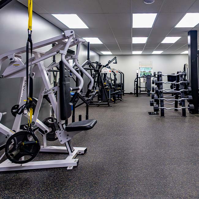 Explore Fitness Center Memberships in Pittsburgh in an empty gym with racks and free weights.