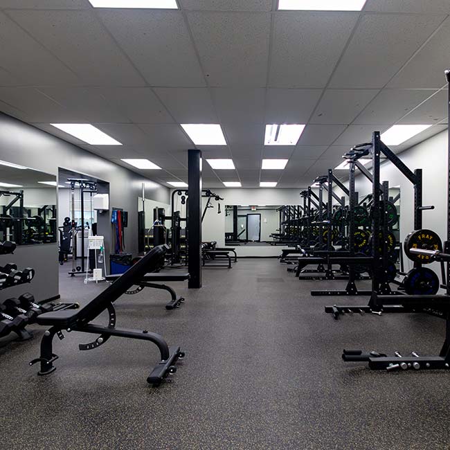 Spacious gym with benches, racks, mirrors—ideal for Fitness Center Memberships in Pittsburgh.