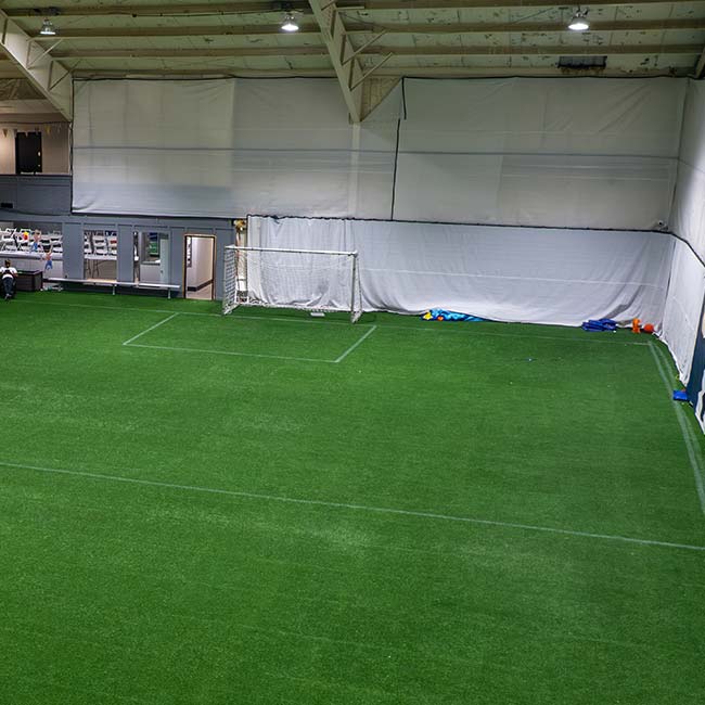 Indoor Field & Court Rentals in Pittsburgh: artificial turf, white walls, and a single goal net.